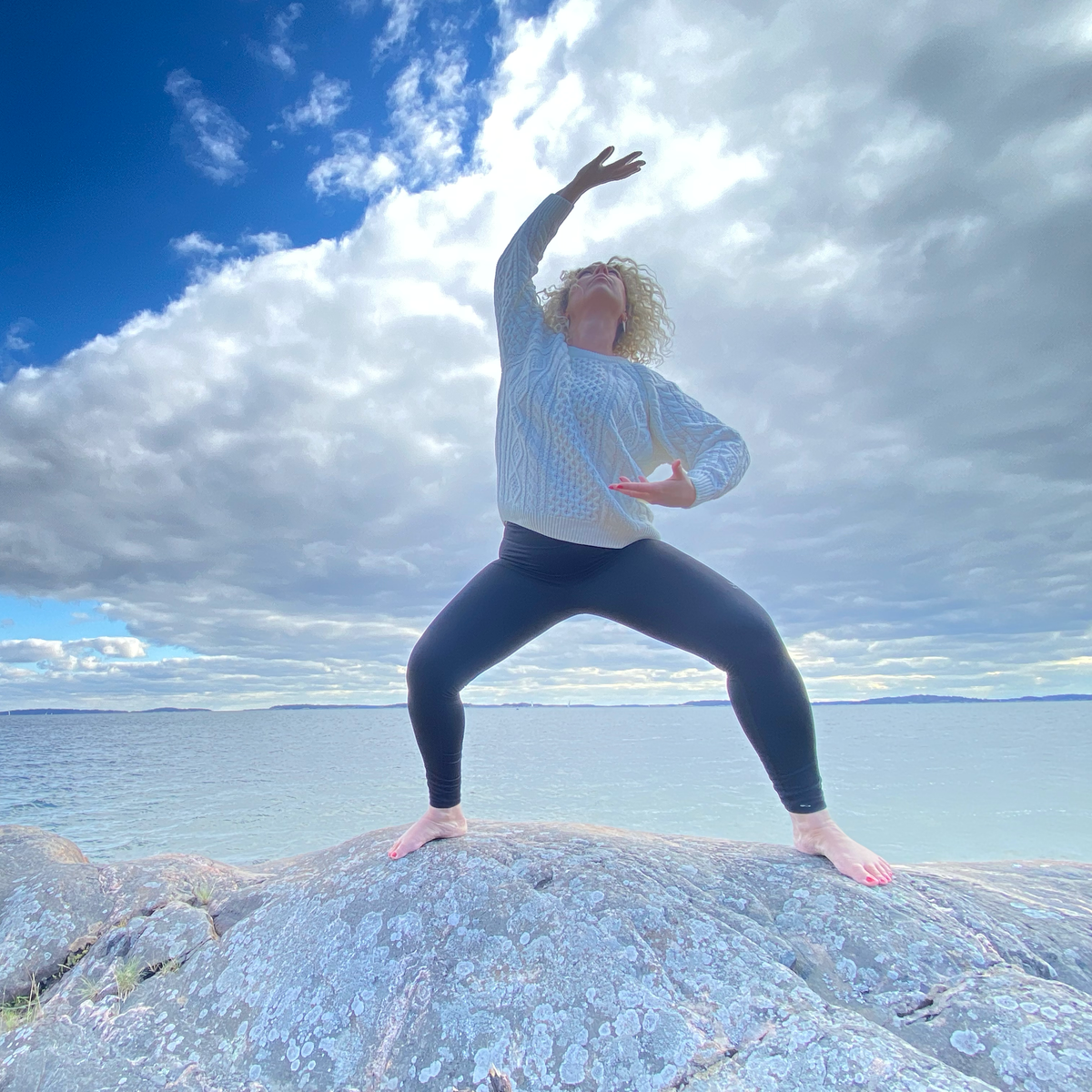 Sanna Fo utövar qigong på en klippa vid havet